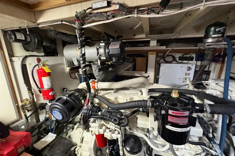 Slide: The Image of Engine room of a 1984 Grand Banks Classic boat, featuring mechanical components and fire extinguisher. - 67