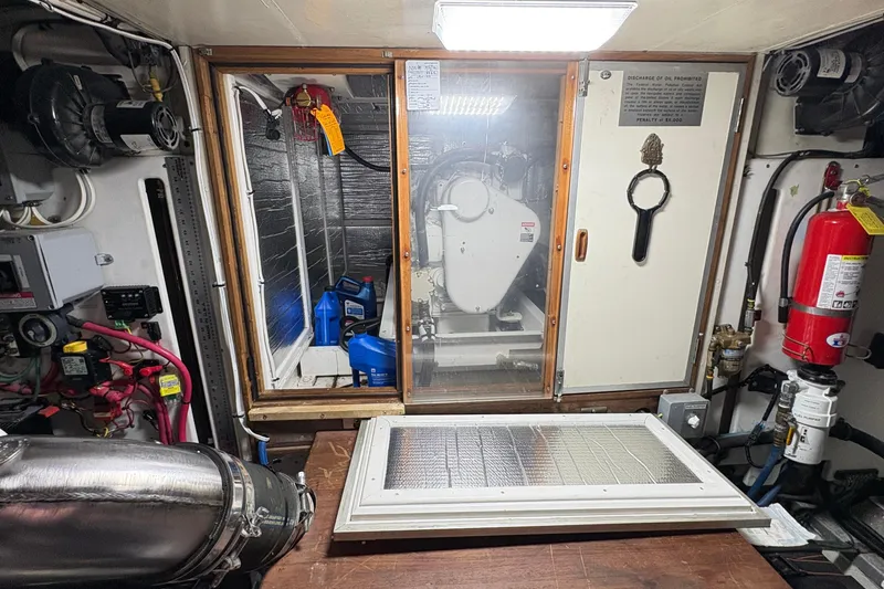 Slide: The Image of Engine room of 1984 Grand Banks 49 Classic yacht with equipment and fire extinguisher. - 68