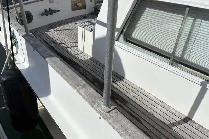 Slide: The Image of 1984 Grand Banks Classic boat deck with wooden flooring and railing. - 9