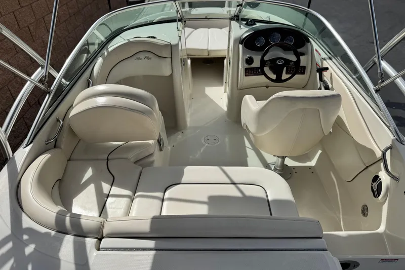 Slide: The Image of 2008 Sea Ray 200 Sundeck interior with white seating and steering console. - 11