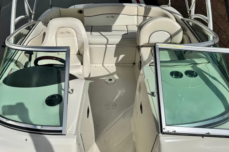 Slide: The Image of 2008 Sea Ray 200 Sundeck interior with beige seating and glass windshields. - 16
