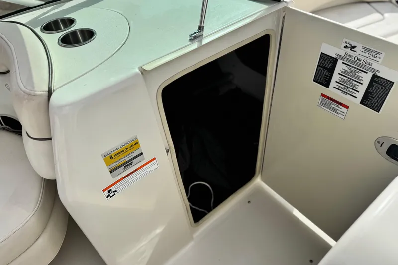 Slide: The Image of 2008 Sea Ray 200 Sundeck interior with storage compartment and cup holders. - 24
