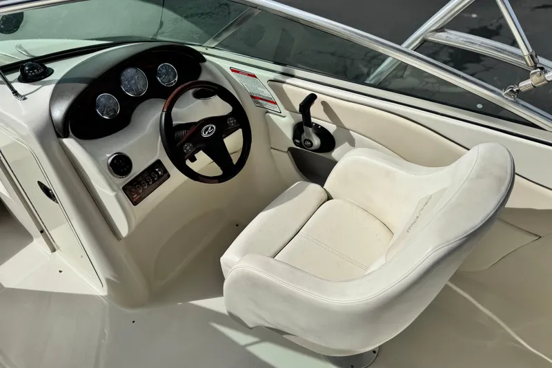 Slide: The Image of 2008 Sea Ray 200 Sundeck helm with steering wheel and white captain's chair. - 25