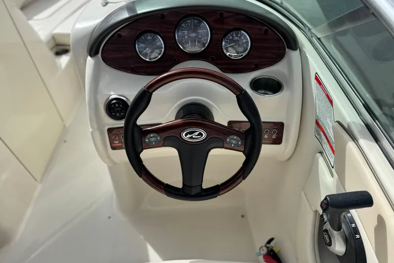 Slide: The Image of 2008 Sea Ray 200 Sundeck steering wheel and dashboard with gauges and controls. - 26