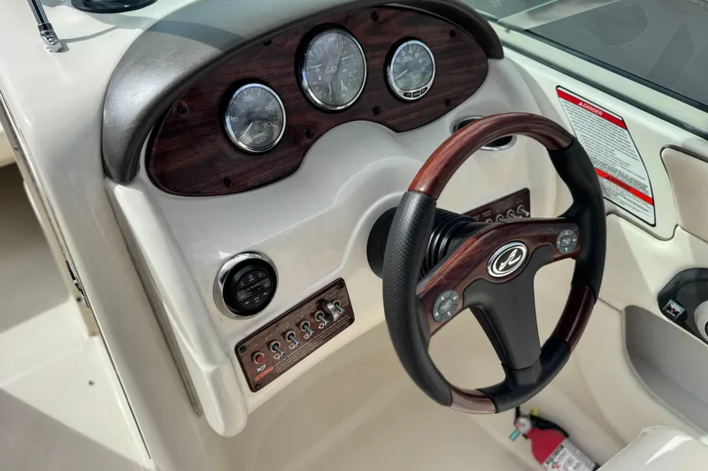 Slide: The Image of 2008 Sea Ray 200 Sundeck dashboard with wood accents and steering wheel. - 27