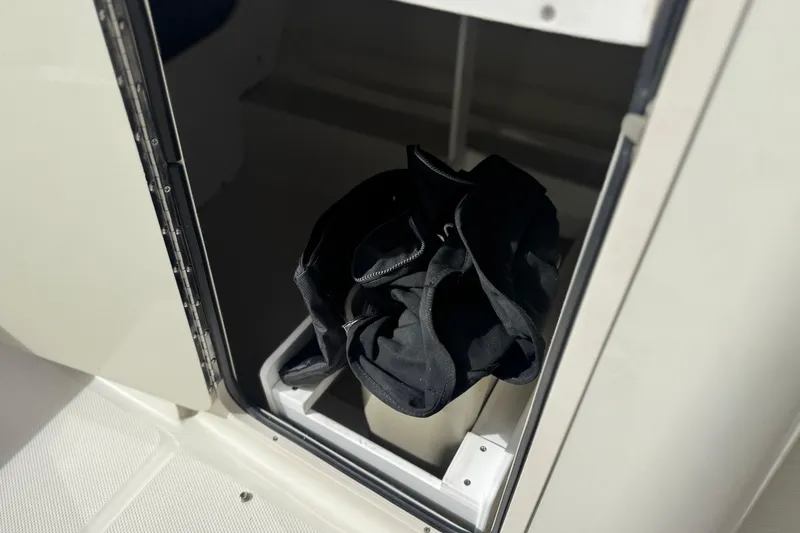 Slide: The Image of Storage compartment on a 2008 Sea Ray 200 Sundeck boat with black bag inside. - 30