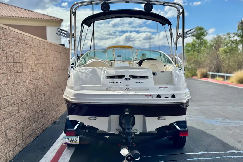 Slide: The Image of 2008 Sea Ray 200 Sundeck boat parked on a driveway, rear view. - 4