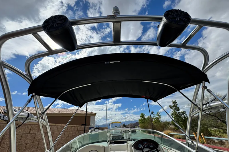 Slide: The Image of 2008 Sea Ray 200 Sundeck boat with canopy under a blue sky. - 8