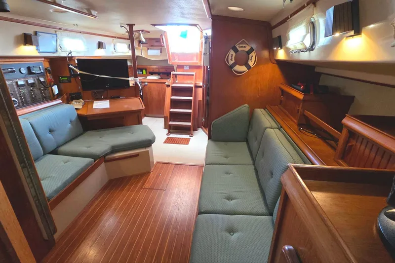 Slide: The Image of 1989 Island Packet 38 sailboat interior with wood finish and cozy seating area. - 12