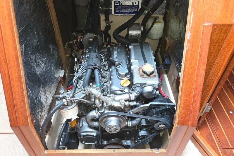 Slide: The Image of Engine compartment of a 1989 Island Packet 38 sailboat, showcasing detailed mechanical components. - 15