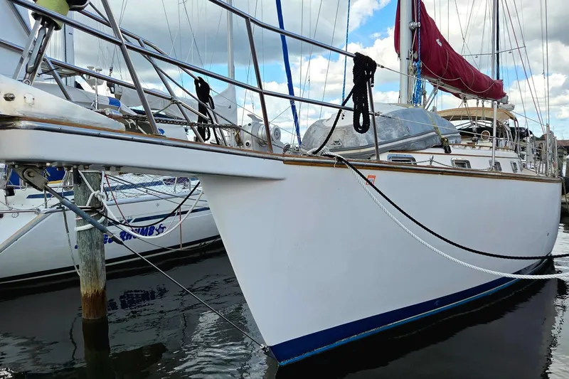 Slide: The Image of 1989 Island Packet 38 sailboat docked, featuring a sleek white hull and maroon sail. - 20