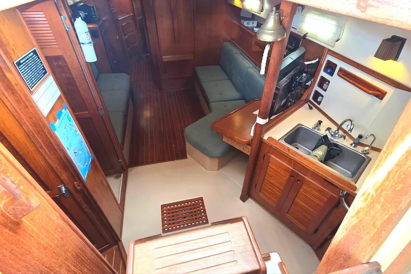Slide: The Image of Interior of 1989 Island Packet 38 sailboat with wooden finishes and compact kitchen area. - 6