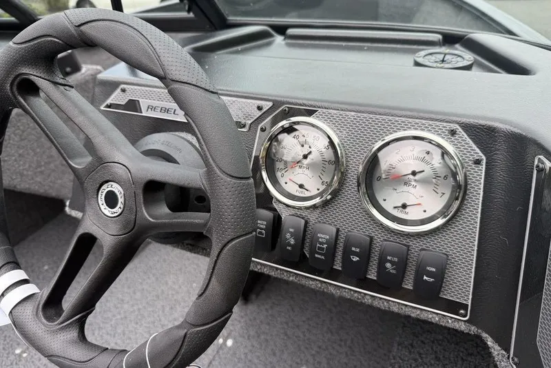 Slide: The Image of 2026 Lund 1650 Rebel SS boat with cover on trailer outside marine store. - 10