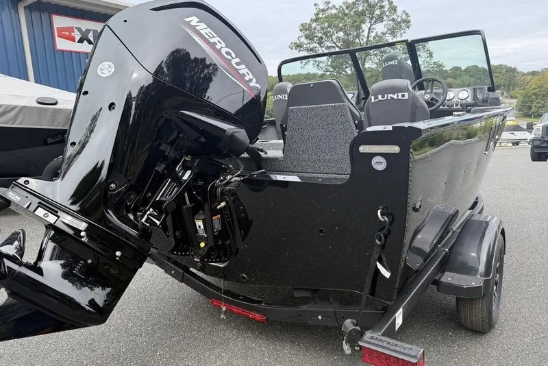 Slide: The Image of 2026 Lund 1650 Rebel SS boat with powerful outboard motor, parked on a trailer. - 12