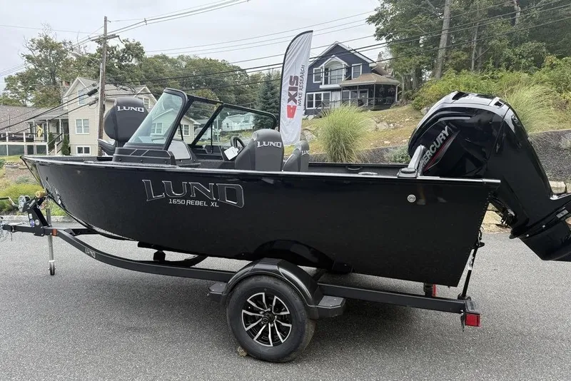 Slide: The Image of 2026 Lund 1650 Rebel SS boat on trailer, parked on street. - 3