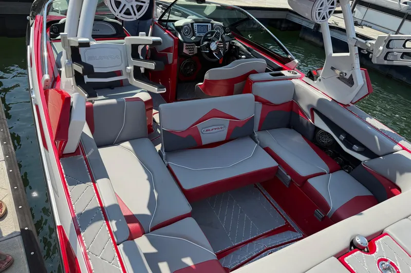 Slide: The Image of 2017 Supra SA450 boat interior with red and gray seating, advanced audio system, and sleek design. - 10