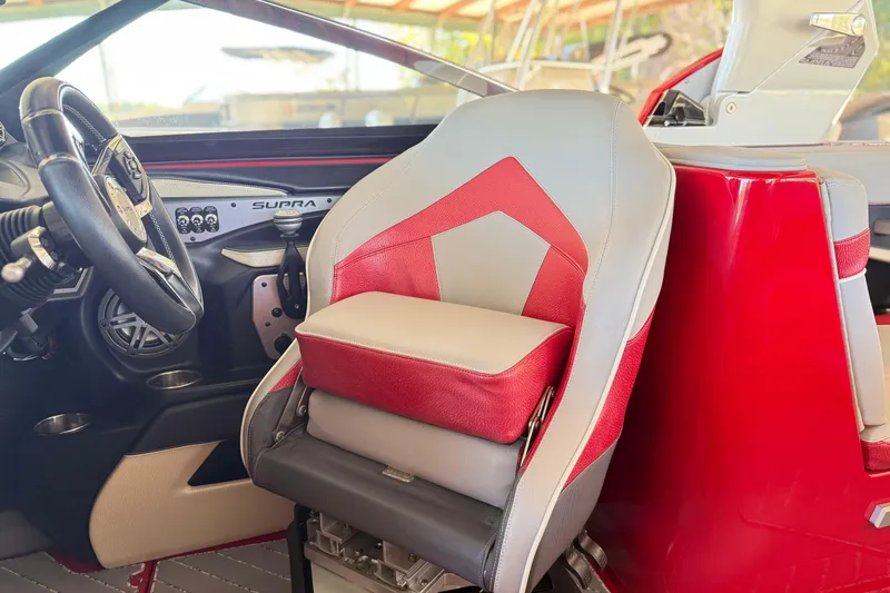 Slide: The Image of 2017 Supra SA450 boat interior with red and gray captain's seat and steering wheel. - 19