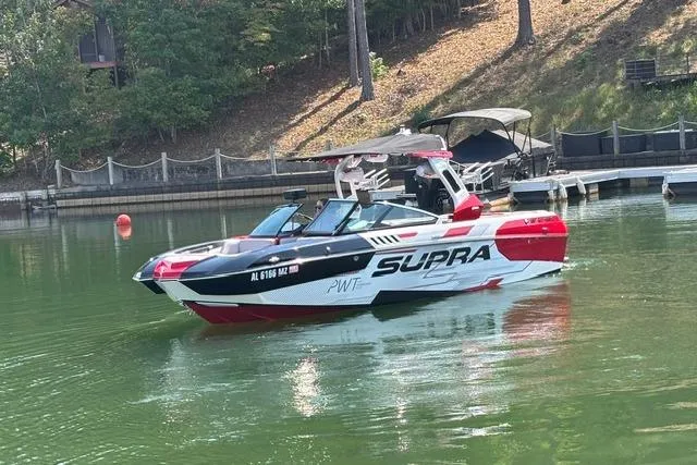 Slide: The Image of 2017 Supra SA450 boat in red and white, parked under a metal roof. - 3
