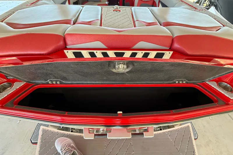 Slide: The Image of 2017 Supra SA450 boat interior with open storage compartment, red and gray seating. - 31