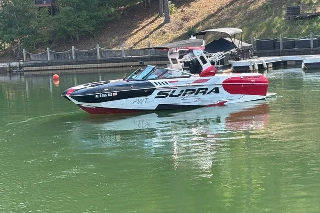 Slide: The Image of Red and white 2017 Supra SA450 boat on trailer under a metal roof. - 5