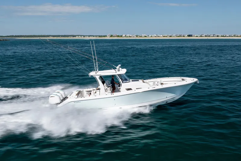 Slide: The Image of 2021 Edgewater 370CC boat cruising swiftly on open water. - 12