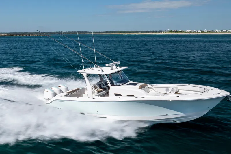 Slide: The Image of 2021 Edgewater 370CC boat cruising swiftly on open water. - 13