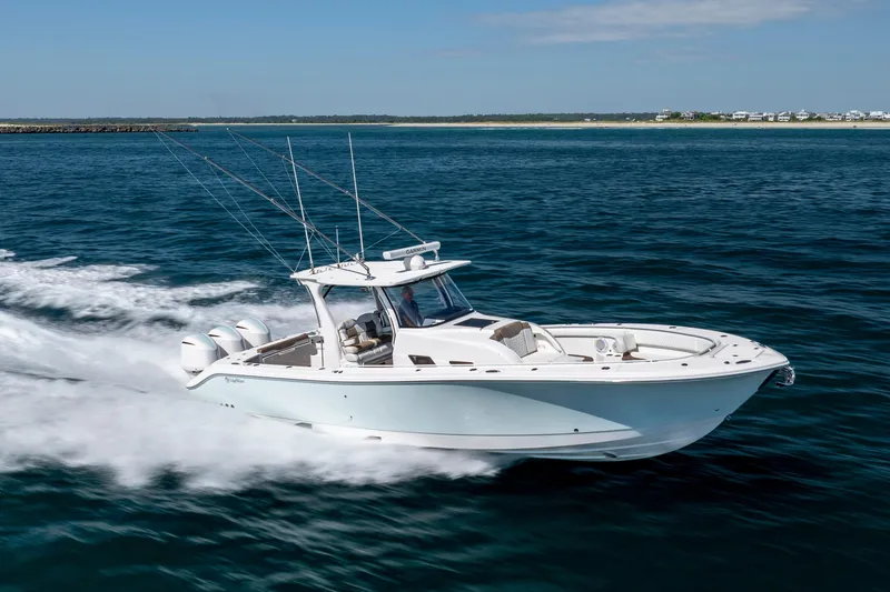 Slide: The Image of 2021 Edgewater 370CC boat cruising on open water, showcasing sleek design and powerful engines. - 14