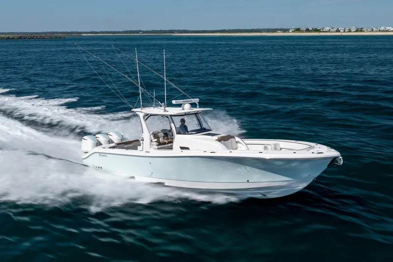 Slide: The Image of 2021 Edgewater 370CC boat cruising on open water, showcasing sleek design and powerful engines. - 15