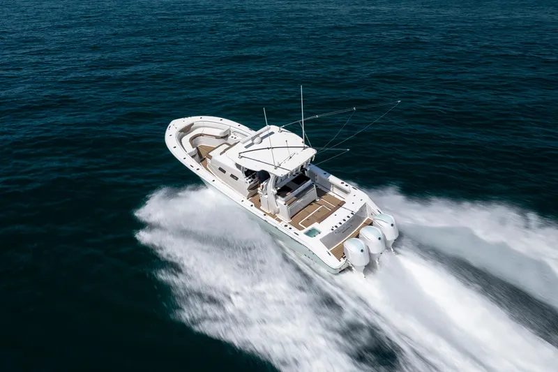 Slide: The Image of 2021 Edgewater 370CC boat cruising swiftly on open water. - 17