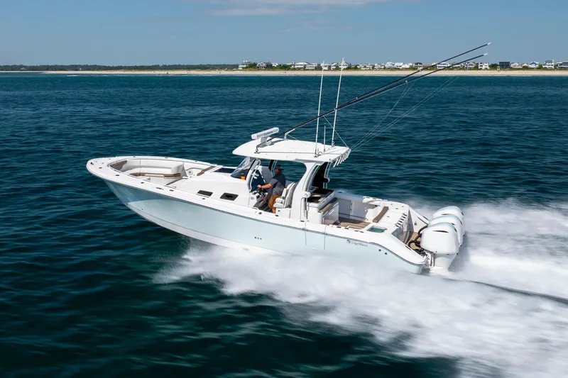 Slide: The Image of 2021 Edgewater 370CC boat cruising on open water, showcasing sleek design and powerful engines. - 18