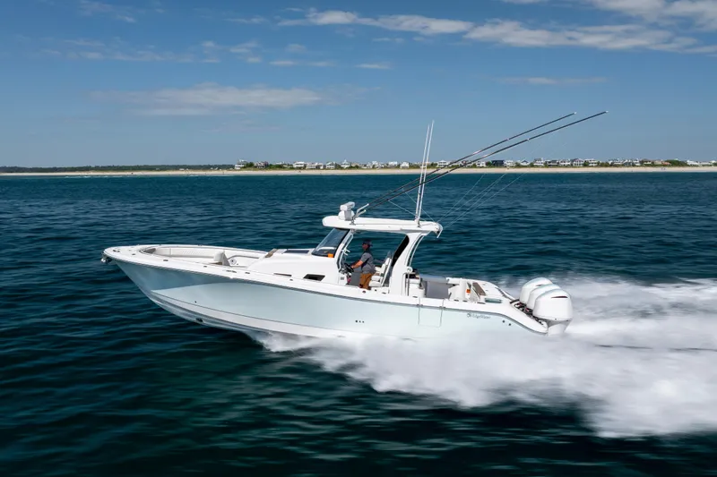 Slide: The Image of 2021 Edgewater 370CC boat cruising on open water under a clear sky. - 19