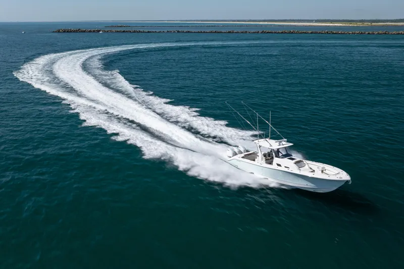 Slide: The Image of 2021 Edgewater 370CC boat cruising swiftly on open water, leaving a trail. - 21