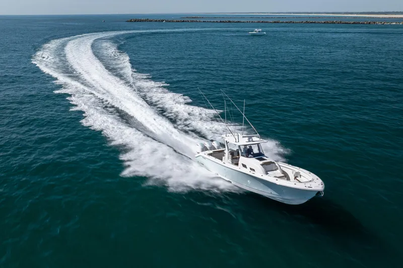 Slide: The Image of 2021 Edgewater 370CC boat cruising swiftly on open blue water. - 22