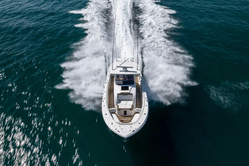 Slide: The Image of 2021 Edgewater 370CC boat cruising on open water, aerial view. - 23