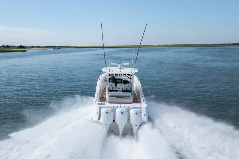 Slide: The Image of 2021 Edgewater 370CC boat speeding on open water, rear view. - 33