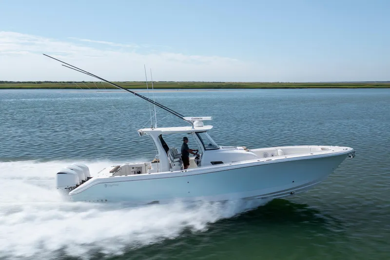 Slide: The Image of 2021 Edgewater 370CC boat cruising on calm water, side view. - 34