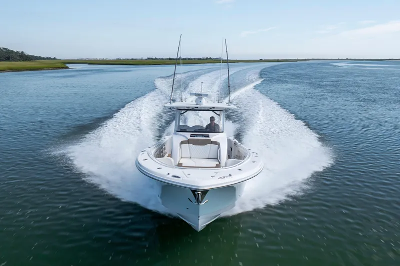 Slide: The Image of 2021 Edgewater 370CC boat cruising swiftly on open water. - 35