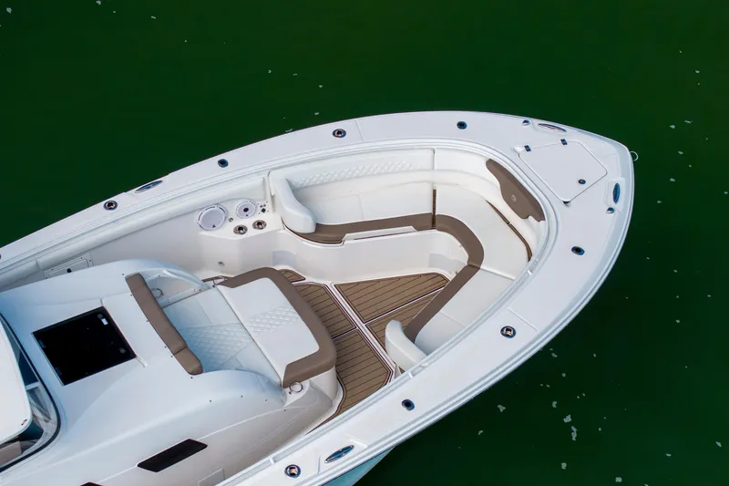 Slide: The Image of 2021 Edgewater 370CC boat interior with white seating and wood accents on green water. - 39