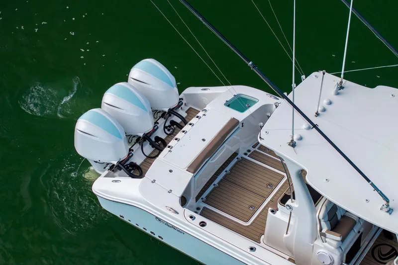 Slide: The Image of 2021 Edgewater 370CC boat with triple outboard engines on green water. - 40