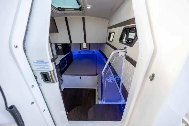 Slide: The Image of Interior of 2021 Edgewater 370CC boat, featuring modern cabin with blue ambient lighting. - 41