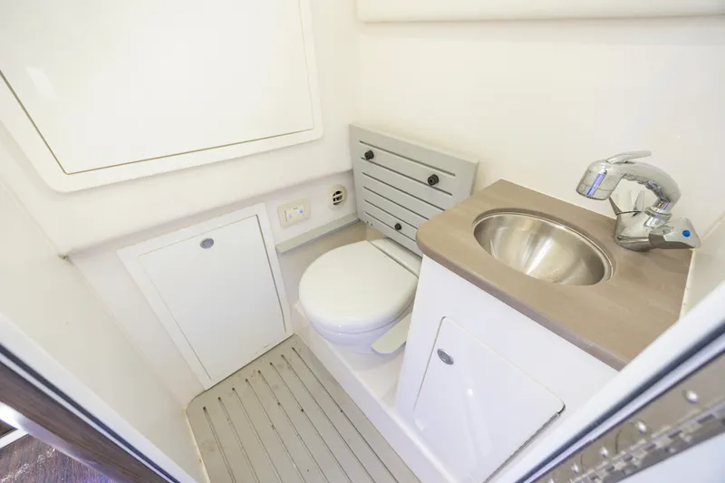 Slide: The Image of 2021 Edgewater 370CC boat bathroom with compact toilet and stainless steel sink. - 47