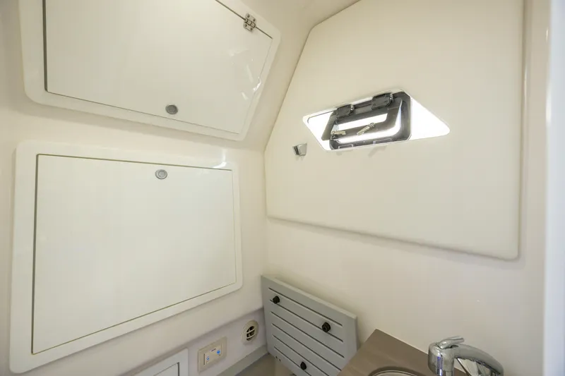 Slide: The Image of 2021 Edgewater 370CC cabin interior with storage compartments and a small window. - 48