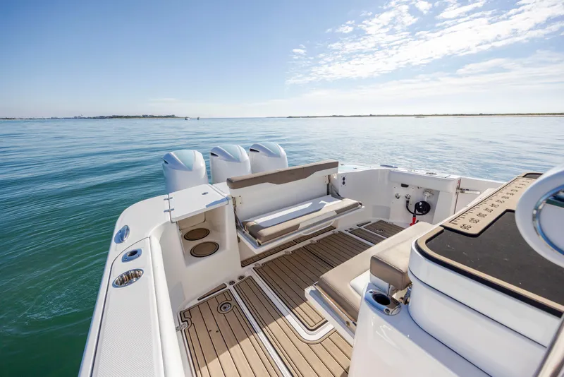 Slide: The Image of 2021 Edgewater 370CC boat on calm water, featuring spacious deck and seating. - 53