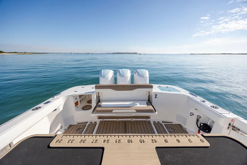 Slide: The Image of 2021 Edgewater 370CC boat deck with triple engines on calm water. - 54