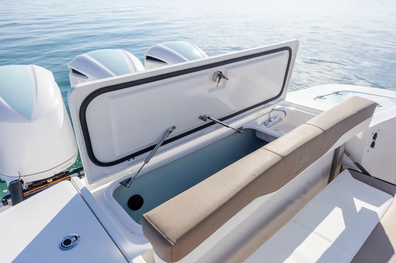 Slide: The Image of 2021 Edgewater 370CC boat with open storage compartment and triple outboard engines. - 57