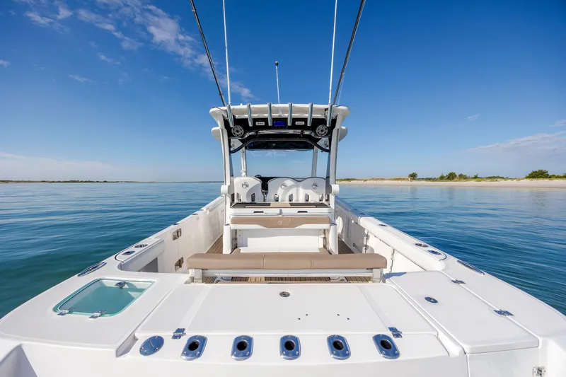 Slide: The Image of 2021 Edgewater 370CC boat on calm water, showcasing spacious deck and seating. - 60