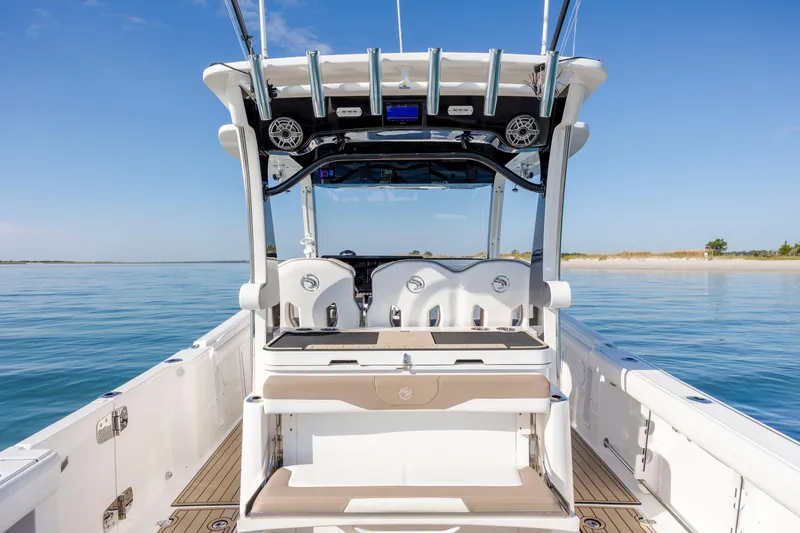 Slide: The Image of 2021 Edgewater 370CC boat interior with seating, ocean view, and clear blue sky. - 61
