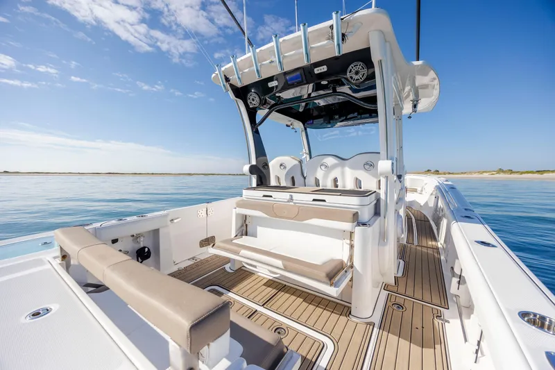 Slide: The Image of 2021 Edgewater 370CC boat interior with seating, ocean view, and clear blue sky. - 62