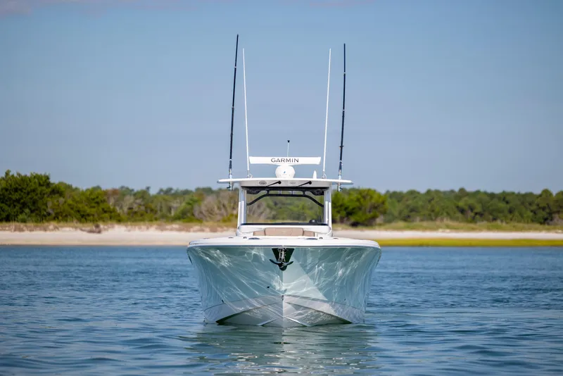 Slide: The Image of 2021 Edgewater 370CC boat on calm water with a scenic shoreline backdrop. - 7