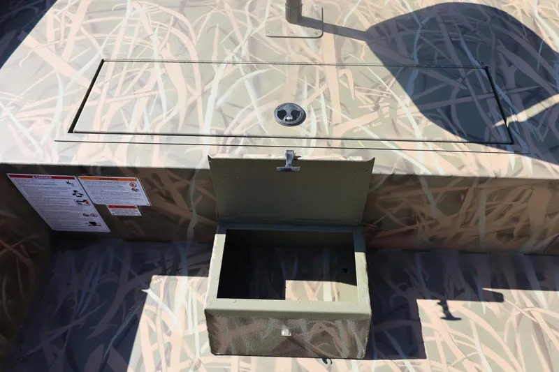 Slide: The Image of 2026 Lowe Roughneck RX2070 SC boat with camo design and open storage compartment. - 11